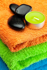 Fototapeta na wymiar background of the three multi colored bath towels, spa black sto