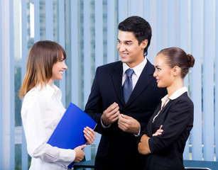 Three young happy businesspeople at office