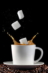 Cup of coffee with splash and sugar cubes