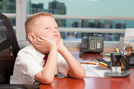 Young boy with a bored expression in a business office