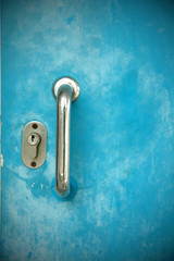 Door handles with  blue metal door .