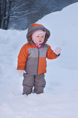 Cute baby walk in deep snow in winter evening