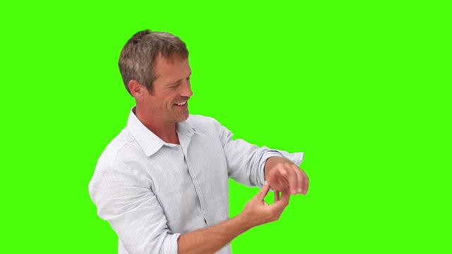 Casual man wearing a shirt putting on his watch