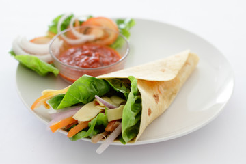 A tortilla wrap on a plate with sauce