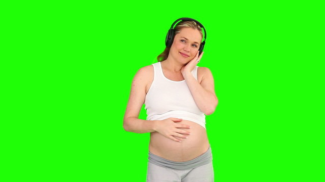 Pregnant woman listening to music with a headphones