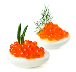 Red caviar canape with quail egg and rosemary twig