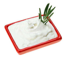Sour cream in red small square plate with rosemary twig