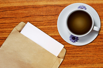Obraz na płótnie Canvas White cup of coffee and brown envelope