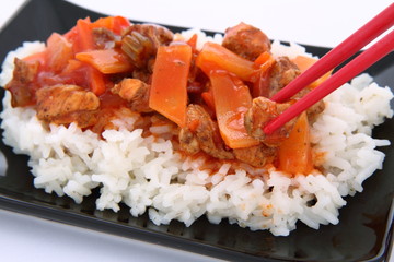 Chinese food-sweet and sour chicken-being eaten with chopsticks