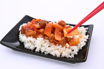 Chinese food-sweet and sour chicken-being eaten with chopsticks