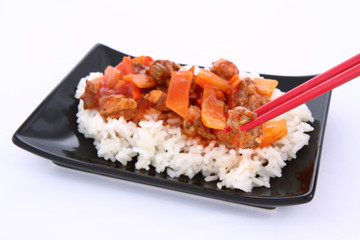 Chinese food-sweet and sour chicken-being eaten with chopsticks