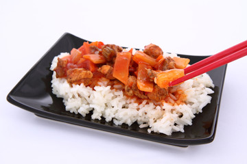 Chinese food-sweet and sour chicken-being eaten with chopsticks