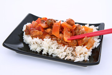 Chinese food-sweet and sour chicken-being eaten with chopsticks
