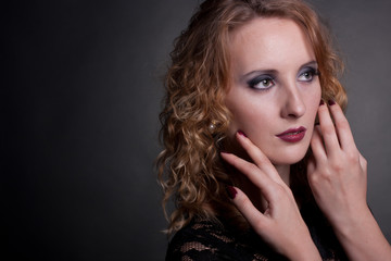 Fototapeta premium Portrait of a beautiful woman with hands near face