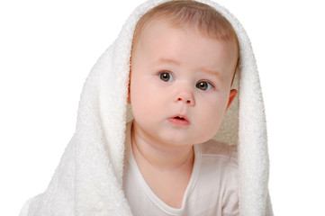The baby under a towel. Age of 8 months. It is isolated on a whi