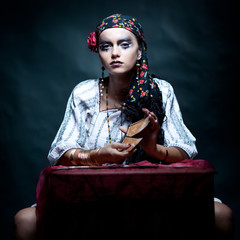 a portrait of a gypsy fortune teller mixing the tarot cards.