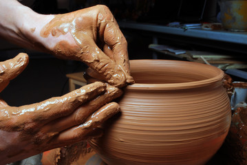 hands of a potter, creating an earthen jar on the circle