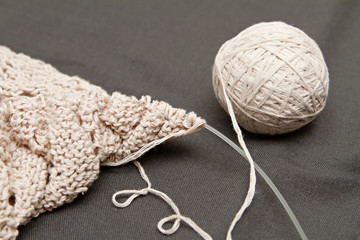 a beige knitted shawl with round needles