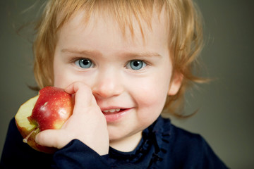 a little beautiful girl eating an apple