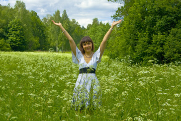 Young woman in white dress on a meadow in blossom