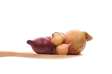 Onions on a wooden spoon isolated on a white background