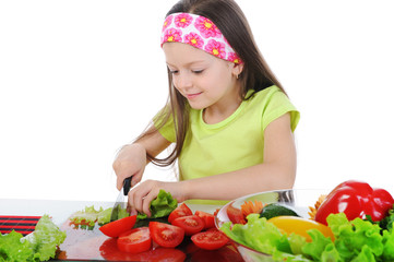 little girl cut fresh tomatoes.