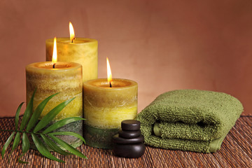 Obraz na płótnie Canvas Spa products with green candles, stones and towel