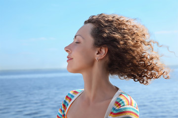 Profile of woman of which in  face blows marine wind