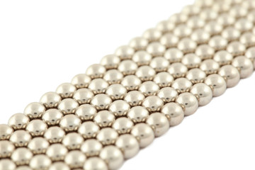 Bar which lies bias consisting of silvery beads on  white