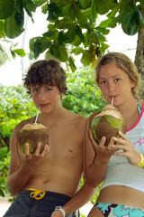 Junge und Mädchen mit tropischem Getränk in Kokosnussschale