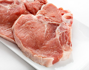 Fresh raw pork with bone on white plate