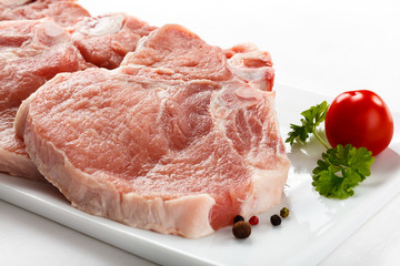 Fresh raw pork with bone on white plate