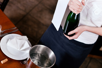 Kellnerin mit Sektflasche in Restaurant