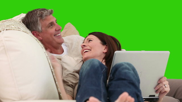 Mature couple laughing in front of a laptop