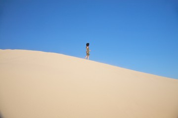 Fototapeta na wymiar woman walking on great sand dune