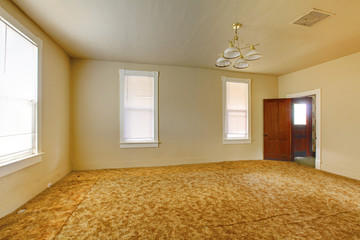 A very old empty living  room with yellow walls