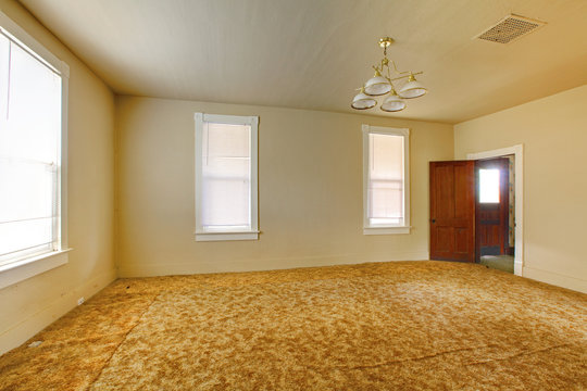 A very old empty living  room with yellow walls