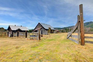 Large old rustic grey barn in the field with mountain