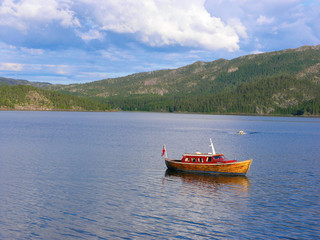 Wooden fishing boat on mountain lake