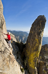 Naklejka premium Rock climber clinging to a cliff.