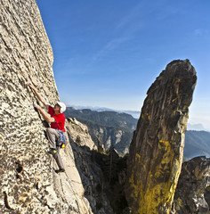 Rock climber clinging to a cliff.