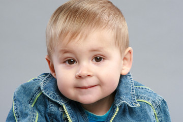 Adorable boy close-up portrait on grey background