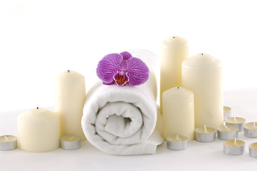Fototapeta na wymiar Spa resort composition - candles, towels, towel and pink orchid
