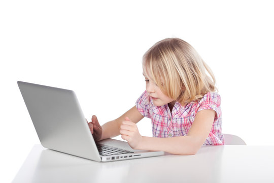 kleines mädchen schreibt am laptop