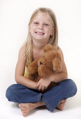 Little girl with a teddy bear smiling funny