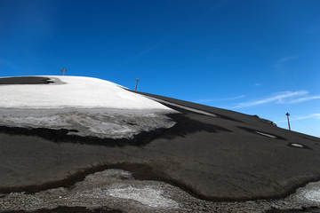 Skilift for skiers on the partially snow covered volcano Etna, L