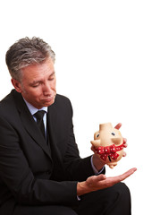 Alter Manager mit leerem Sparschwein