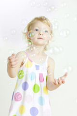 Obraz na płótnie Canvas portrait of little girl with bubbles