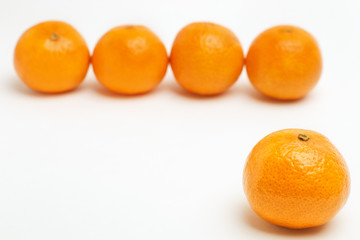 Tangerine in front in focus with blurred row of mandarins