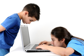 Teen girl working on computer while cute boy looking,